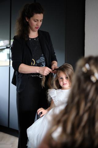Bruidsmeisje krijgt haaropmaak van stylist voor trouwceremonie, bruidsfotografie Sodafabriek Schiedam - Trouwshoot Stefan Seg