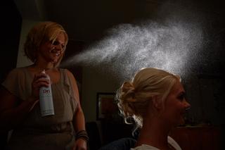 Bruid Jooske krijgt haarspray opgespoten voor bruiloft, voorbereiding bruidsfotografie Witte Huis Loosdrecht - Trouwshoot Ste
