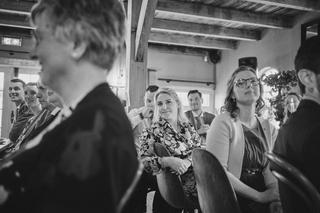 Gasten volgen het moment tijdens de ceremonie van Ilse en Robbert op Boerderij Burgersdijk - Trouwshoot Stefan Segers