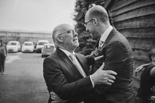 Robbert en zijn vader delen een emotioneel moment buiten Boerderij Burgersdijk in De Lier - Trouwshoot Stefan Segers