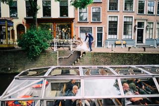 Bruidspaar Manon en Alvin bij gracht Oostpoort Delft, grachtenboottocht trouwreportage Prinsenhof - Trouwshoot Stefan Segers
