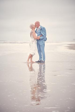 Bruidspaar Silvia en Patrick kust op het strand bij Beachhouse Kijkduin Den Haag, romantische trouwreportage - Trouwshoot Ste