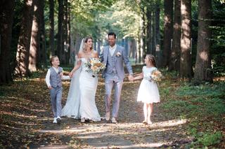 Bruidspaar Carlo en Lucinda met bruidskinderen wandelen hand in hand door bospad Kasteel Sypesteyn Loosdrecht, trouwreportage