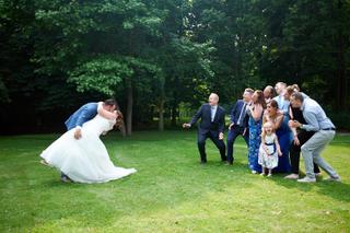 Bruidspaar Kelly en Melvin kusjes geven tijdens groepsfoto met familie in park - Trouwshoot Stefan Segers