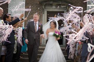 Bruidspaar Melissa en Michel verlaten kerk onder roze linten, trouwreportage Museum Hoffwijk Voorburg - Trouwshoot Stefan Seg