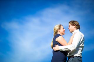 Verliefd koppel omhelst elkaar tegen blauwe hemel, loveshoot koppelfotografie — Trouwshoot Stefan Segers