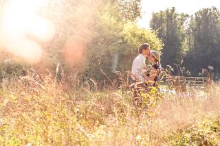 Bruidspaar kust in wildveld tijdens gouden uur, romantische loveshoot in de natuur — Trouwshoot Stefan Segers