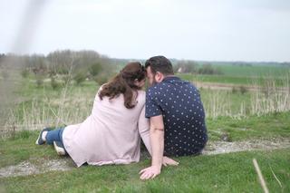Koppel zittend in groen landschap Zoetermeer, intieme loveshoot moment — Trouwshoot Stefan Segers