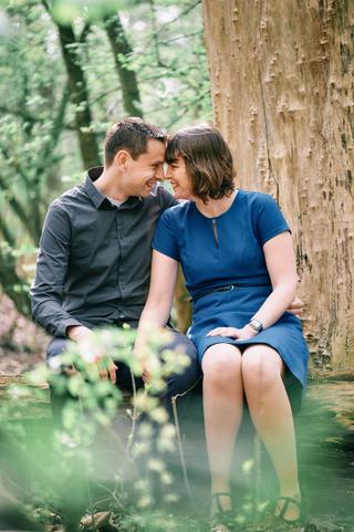 Verliefd koppel zit lachend tegen oude boom in Zoetermeer, loveshoot koppelfotografie — Trouwshoot Stefan Segers