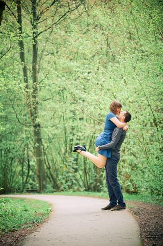 Bruidegom tilt bruid op in bosrijke omgeving Zoetermeer, speelse loveshoot moment — Trouwshoot Stefan Segers
