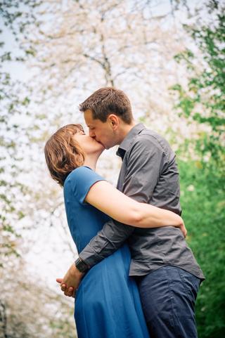 Stelletje kust elkaar voor witte bloesemboom in Zoetermeer, romantische loveshoot — Trouwshoot Stefan Segers