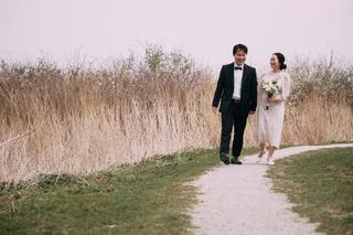 Bruidspaar loopt hand in hand over zandpad langs rietland in Zoetermeer, herfst loveshoot — Trouwshoot Stefan Segers