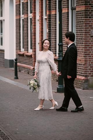 Bruidspaar hand in hand op straatje in Zoetermeer, loveshoot met vintage sfeer — Trouwshoot Stefan Segers