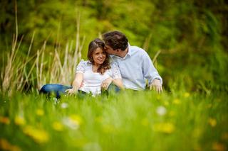 Verliefd koppel zit in groen veld met bloemen, loveshoot in Zoetermeer — Trouwshoot Stefan Segers