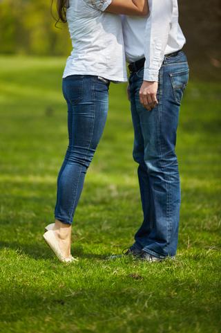 Verliefd stel in jeans en wit shirt knuffelend op groen gras in Zoetermeer, loveshoot — Trouwshoot Stefan Segers