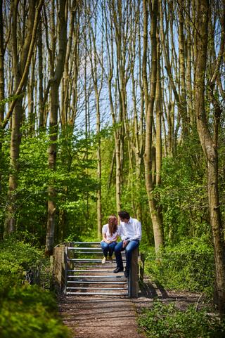 Verliefd koppel zit samen op houten brug in het bos van Zoetermeer, loveshoot — Trouwshoot Stefan Segers