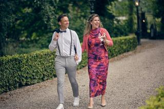 Renee en Fabian lopen hand in hand over de oprijlaan van Kasteel Wijnenburg in Echteld, stralenend van geluk op hun trouwdag