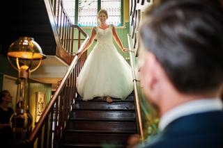 Bruid Kirsten daalt trappen af in witte jurk naar bruidegom Jouke in Park Hugo de Vries Lunteren - Trouwshoot Stefan Segers