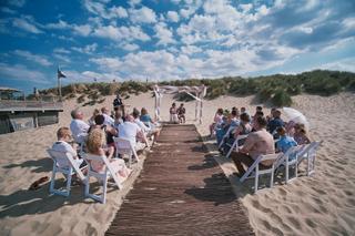 Bruidspaar Mirjam en Jorg ceremonie op het strand bij Strandpaviljoen Brouw Ouddorp, trouwreportage met gasten, zeebruidegom