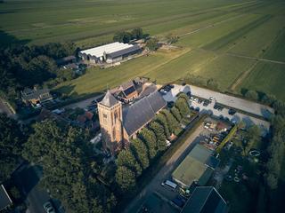 Luchtfoto van Het Dikke Torentje met de bruidspaar Bram en Elles: spectaculair vogelvluchtperspectief van deze prachtige trou