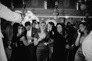 Gezellige bruidsgasten dansen en lachen op het bruiloftsfeest, sfeervolle trouwreportage feestfotografie - Trouwshoot Stefan