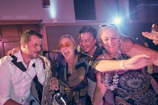 Bruidspaar Bram en Elles feesten met saxofonist op trouwreportage Het Dikke Torentje, vrolijke bruiloftsfeer - Trouwshoot Ste