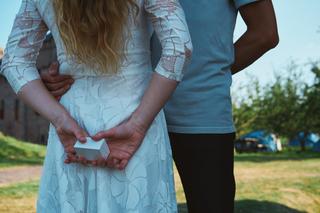 Het huwelijksaanzoek van Yvonne aan Bert bij het Muiderslot. Een intiem moment met de ring in handen - Trouwshoot Stefan Sege