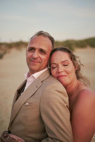 Bruidspaar Mirjam en Jorg omhelsd op het strand bij Ouddorp, romantische trouwreportage Ravense Hout - Trouwshoot Stefan Sege