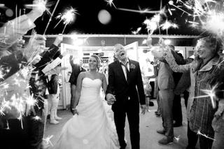 Bruidspaar loopt hand in hand door sterrenkransen met sparklers, festelijke trouwreportage - Trouwshoot Stefan Segers