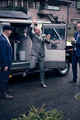 Bruidegom springt juichend uit auto bij trouwlocatie Wipelberg Veluwe - Trouwshoot Stefan Segers