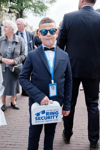 Bruidsjongentje Sem speelt rol als beveiligingsagent op bruiloft Raquel en Mark in Enspijk - Trouwshoot Stefan Segers