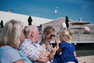 Bruidsfamilie geniet op terras Strandpaviljoen Brouw Ouddorp, bruidspaar Mirjam en Jorg trouwreportage - Trouwshoot Stefan Se