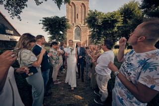 Bruidspaar Bram en Elles danst met gasten bij historische kerk Het Dikke Torentje, vrolijke trouwreportage - Trouwshoot Stefa