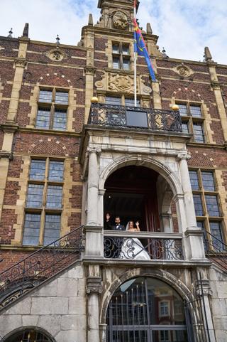 Bellina en Cem zwaaien vanaf het balkon van het Venlose stadhuis na hun ceremonie - Trouwshoot Stefan Segers