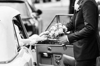 Bruidspaar Kim en Mike wisselen bloemen uit bij stadhuis Schiedam, trouwceremonie zwart-wit - Trouwshoot Stefan Segers