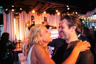 Bruidspaar Liad en Wilfried dansen samen op trouwreceptie The Boathouse Kralingen, sfeervolle avondfeest met warm licht - Tro