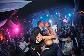 Bruidspaar Liad en Wilfried zoenen tijdens feestelijk dansen in verlichte zaal The Boathouse Kralingen, trouwreportage Kralin