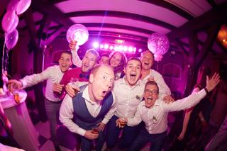 Bruidspaar Mark en Kelly feesten met gasten op dansfeest, paarse neonverlichting - Trouwshoot Stefan Segers