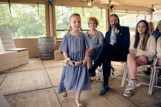 Bruidsmeisje in blauwe jurk loopt door de ceremoniezaal onder toeziend oog van Marco, Tamara en gasten op Breeze - Trouwshoot