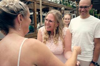 Bruid Tamara lacht voluit met gasten op het terras van trouwlocatie Breeze in Vierpolders - Trouwshoot Stefan Segers