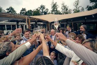 Marco en Tamara proost met gasten onder het zeil op Breeze in Vierpolders - Trouwshoot Stefan Segers