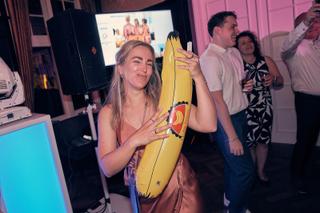 Bruidsgasten dansen uitgelaten op receptie met opblaasbare banan, trouwfeest Kasteel De Hooge Vuursche Rotterdam - Trouwshoot
