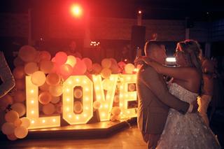 Bruidspaar Jacky en Jordy danst bij verlicht LOVE-bordje, avondreportage Wantij Paviljoen Dortrecht - Trouwshoot Stefan Seger