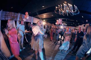 Bruidspaar Jacky en Jordy dansen met gasten op feestje, roze ballonnen en moderne kroonluchter, trouwfeest Wantij Paviljoen D