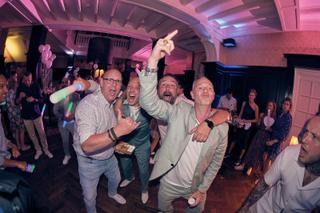 Bruidegom Dennis en gasten dansen feestelijk op trouwreceptie Kasteel De Hooge Vuursche Rotterdam, trouwfeest met roze neonve
