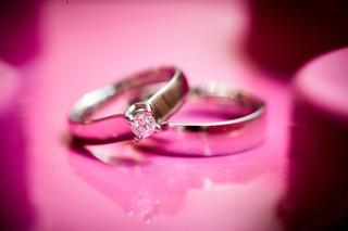 Trouwringen met diamanten verlovingsring op roze bloemen close-up - Trouwshoot Stefan Segers