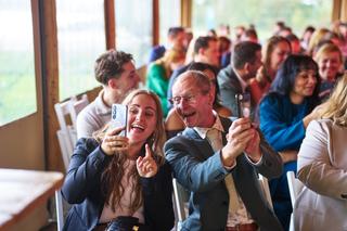 Karlijn en Glenn delen een lachmoment met hun gasten tijdens de bruiloft - een selfie-moment vol energie en vreugde in Breezz
