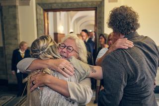 Tijdens de bruiloft van Jiska en Gerrit in het Stadhuis van Rotterdam: emotioneel moment met familie die elkaar omhelst in he