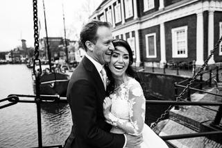 Bruidspaar Mike en Kim lacht samen op bootje bij stadhuis Schiedam - Trouwshoot Stefan Segers