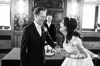 Bruidspaar Mike en Kim lacht samen bij stadhuis Schiedam, trouwceremonie kerk, zwart-wit trouwreportage - Trouwshoot Stefan S